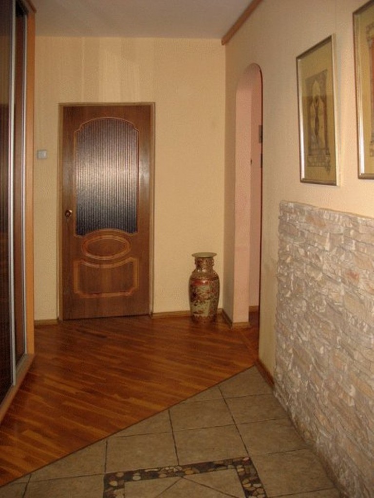 Отделка пола керамической плиткой перед дверью в прихожей