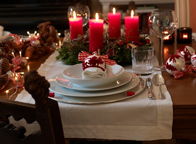 Композиция с хвоей и большими яркими свечами в центре стола. Шишки, шары, включенная электрическая гирлянда служат акцентами, поддерживающими рождественскую тему